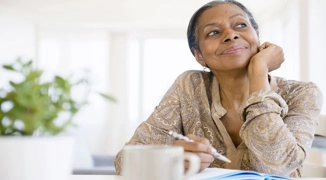 Woman smiling with her journal and pen in hand