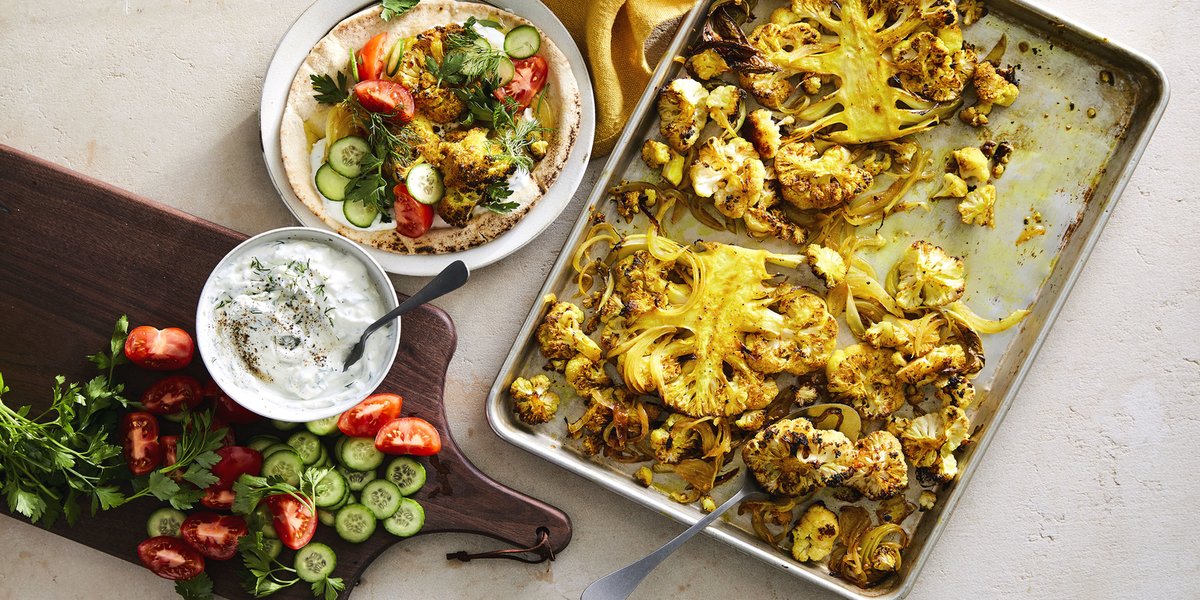 Shawarma cauliflower pita tzatziki plated on table with yellow napkin and silver spoon